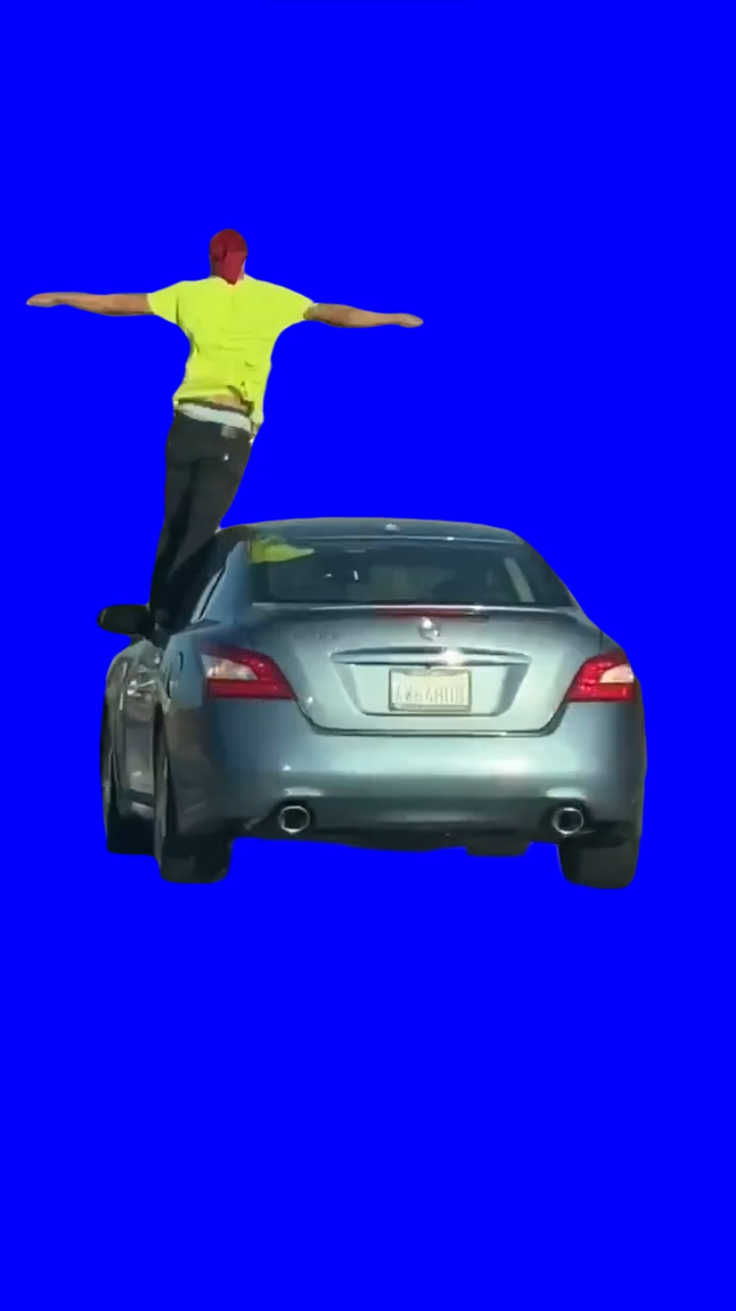 Man lets car drive itself while standing on top car window (Green Screen)